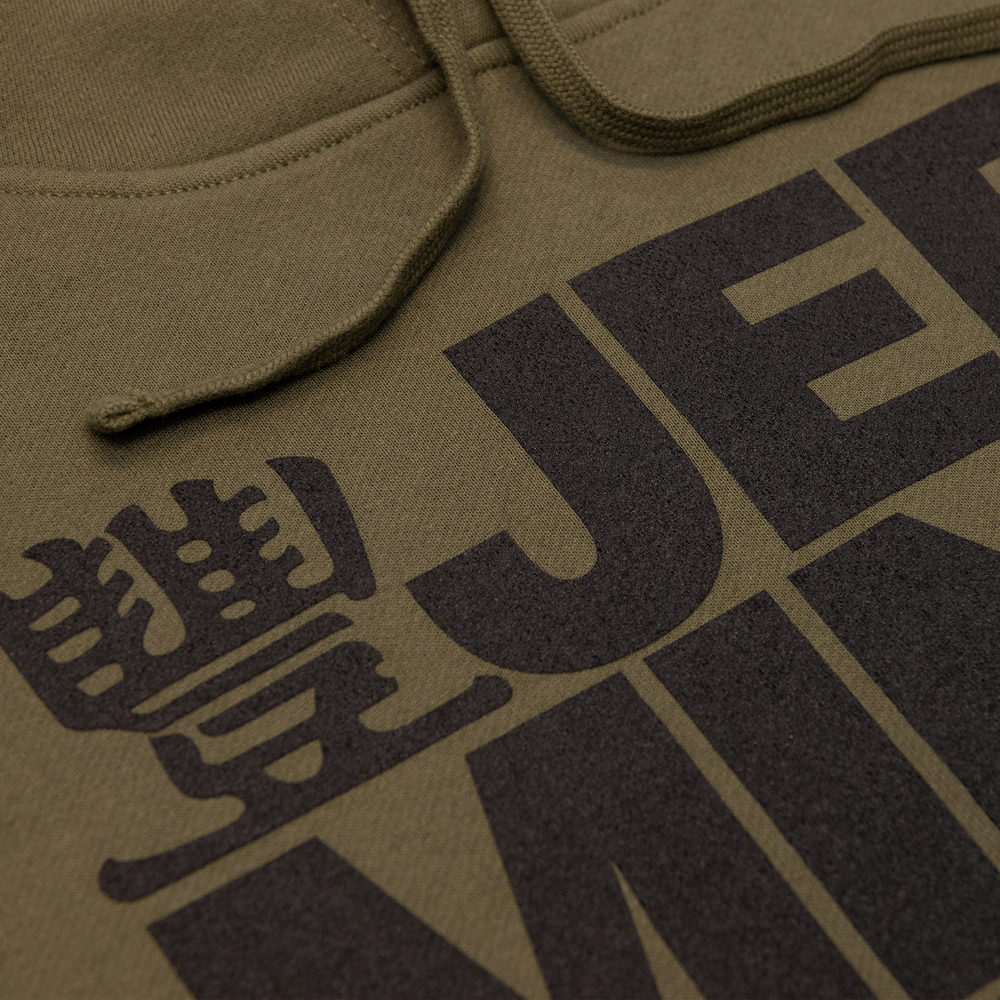 Close up shot of JMT Stacked Logo Hoodie Black on Army Green