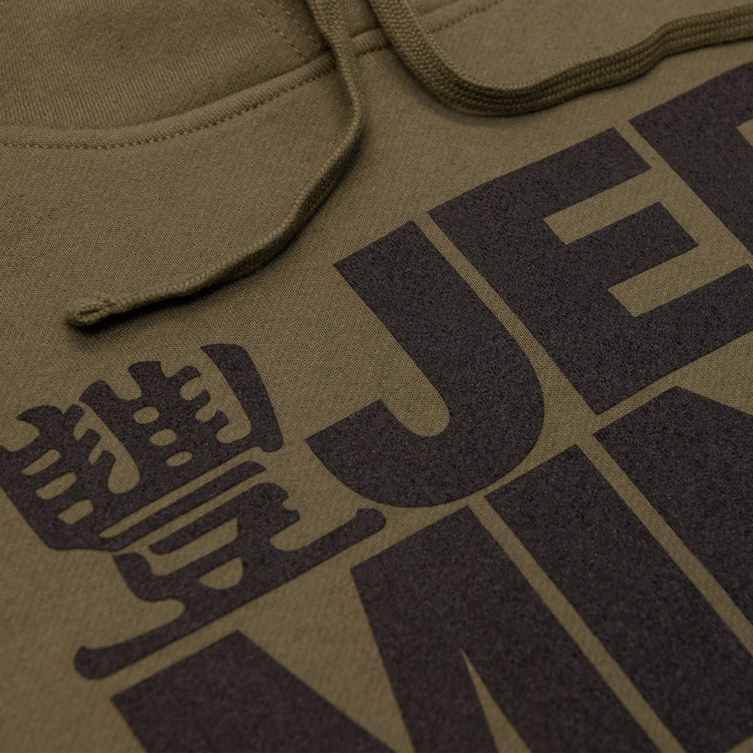 Close up shot of JMT Stacked Logo Hoodie Black on Army Green