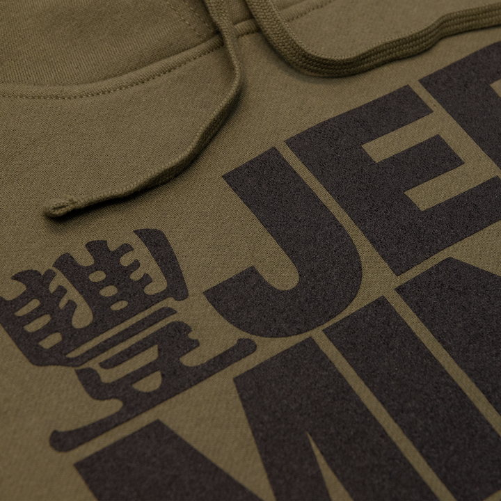 Close up shot of JMT Stacked Logo Hoodie Black on Army Green